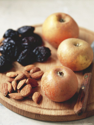 Apples, Prunes and Almonds on Wooden Board